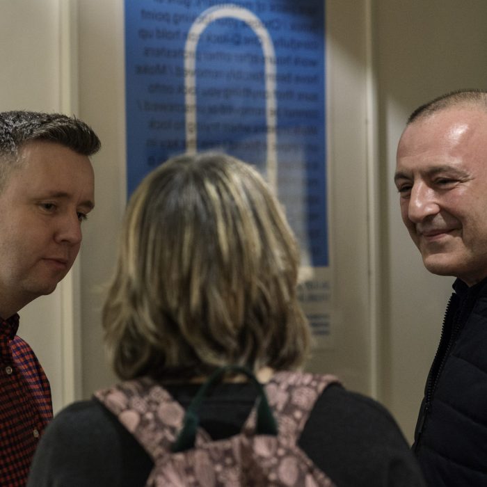 Artistic Director Dinos Aristidou stood talking with 2 people at our project launch.