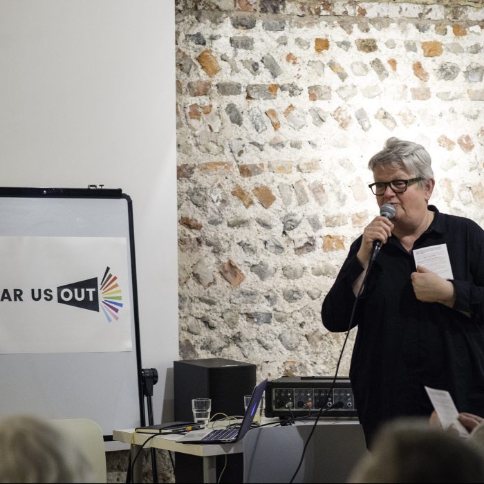 New Writing South's Chief Executive Lesley Wood speaks at our launch. She has short grey hair, glasses and a microphone,