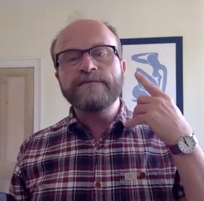 Bruce Guthrie leading a Zoom workshop. He has brown balding hair, facial hair and glasses and is addressing the camera.